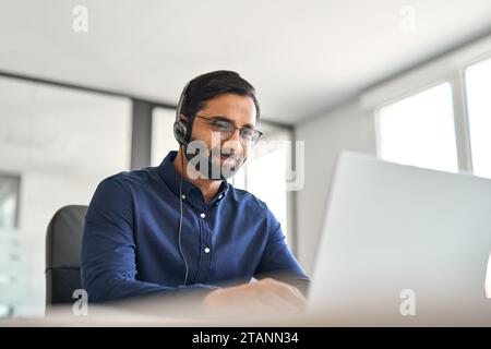 Indian call center agent wearing headset working on customer support service. Stock Photo