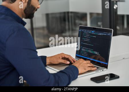 Busy businessman software developer working on computer in office. Over shoulder Stock Photo