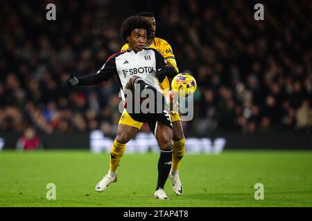 LONDON, UK - 27th Nov 2023:  Willian of Fulham FC holds off the challenge from Nelson Semedo of Wolverhampton Wanderers during the Premier League matc Stock Photo