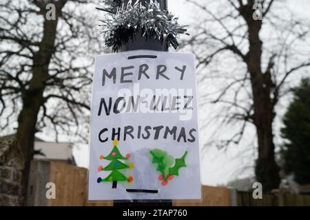 Harefield, UK. 2nd December, 2023. Anti Ultra Low Emission Zone (ULEZ) 'Blade Runners' have been busy in Harefield in the London Borough of Hillingdon. They have covered a ULEZ camera with a red box and a picture of Sadiq Khan wearing a bow tie. The pole is also wrapped in Christmas tinsel with a sign saying 'Merry Non-ULEZ Christmas. The Conservative Mayoral Candidate, Susan Hall, commenting on a recent report on ULEZ said that it 'proves once again that Sadiq Khan's ULEZ expansion is nothing but a tax grab'. Credit: Maureen McLean/Alamy Live News Stock Photo