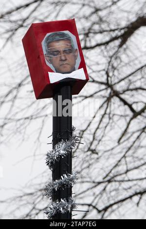 Harefield, UK. 2nd December, 2023. Anti Ultra Low Emission Zone (ULEZ) 'Blade Runners' have been busy in Harefield in the London Borough of Hillingdon. They have covered a ULEZ camera with a red box and a picture of Sadiq Khan wearing a bow tie. The pole is also wrapped in Christmas tinsel with a sign saying 'Merry Non-ULEZ Christmas. The Conservative Mayoral Candidate, Susan Hall, commenting on a recent report on ULEZ said that it 'proves once again that Sadiq Khan's ULEZ expansion is nothing but a tax grab'. Credit: Maureen McLean/Alamy Live News Stock Photo