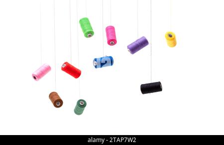 Various spools of sewing cotton thread of different colors floating. Stock Photo