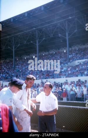 SACRAMENTO, CA - AUGUST, 1958: A group of men tend to the driver after his car flipped and crashed during a car show at the Sacramento State Fair circa August, 1958 in Sacramento, California. (Photo by Hy Peskin) Stock Photo