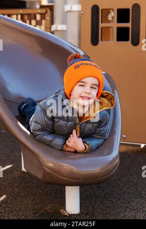 Young child playing on sliding board; outdoors playground; Philadelphia; Pennsylvania; USA Stock Photo