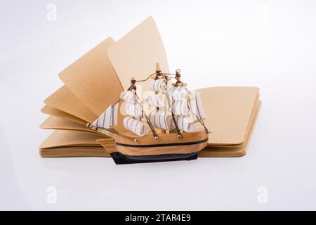 Old Ship on a notebook on a white background Stock Photo