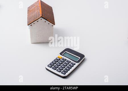 Model house and calculator placed on white background Stock Photo