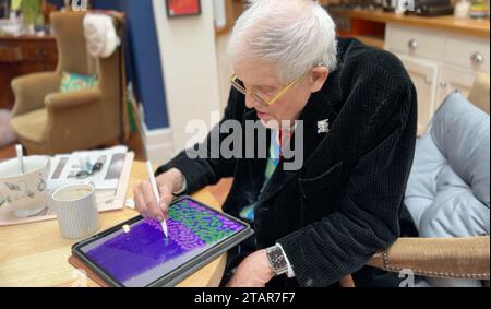 Undated handout photo issued by Apple of David Hockney creating Christmas-themed artwork which is displayed at Battersea Power Station in London. The artist, who is known for using a range of mediums including apps on iPhones, used an iPad Pro and Apple Pencil to create the design. Issue date: Saturday December 2, 2023. Stock Photo