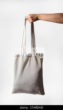 Hand holding canvas tote bag mockup. Textile cloth shopper for grocery Stock Photo