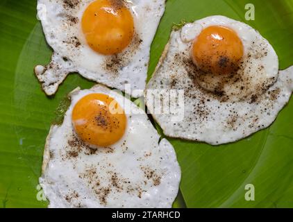 Closeup Image Of Three Sunny Side Up Eggs In Green Plate Stock Photo