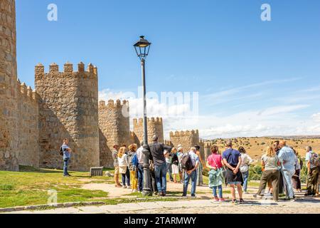 Tourists on  a guided walk by the ramparts of the fortified city walls in the Spanish walled city of  Avila in the community of Castile and León Spain Stock Photo