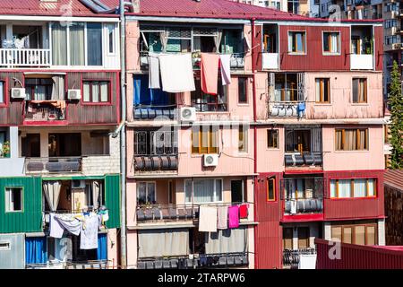 travel to Georgia - apartment building in residential district in Batumi city with laundry drying on balcony on sunny autumn day Stock Photo