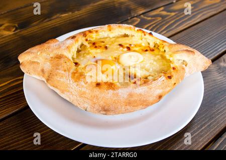 travel to Georgia - khachapuri in Adjarian style (boat shaped with soft cheese, egg, butter) in local cafe in Batumi city Stock Photo