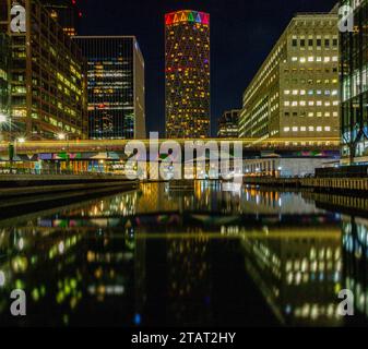 Night time at Canary Wharf and Middle Dock surrounded by sky scrapers Stock Photo