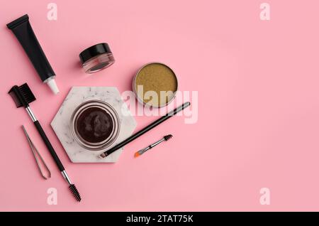 Flat lay composition with eyebrow henna and tools on pink background. Space for text Stock Photo