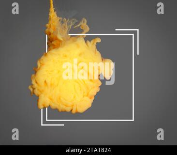 Splash of yellow ink and frame on grey background Stock Photo