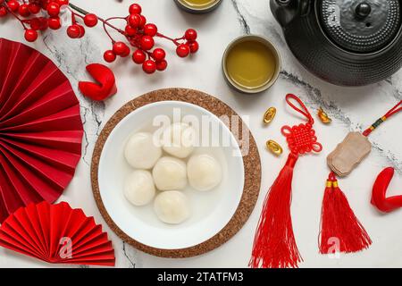 Bowl of tangyuan with teapot, cup and berries on white wooden ...