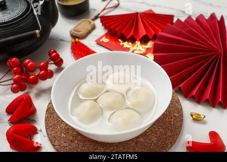 Bowl of tangyuan, fortune cookies, Chinese decor and sakura on pink ...