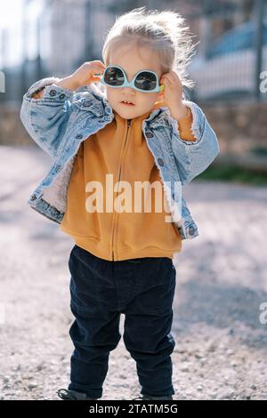 Little girl trying on sunglasses upside down Stock Photo