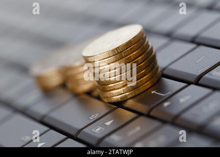 Stacks of coins on a computer keyboard. Online shopping concept Stock Photo