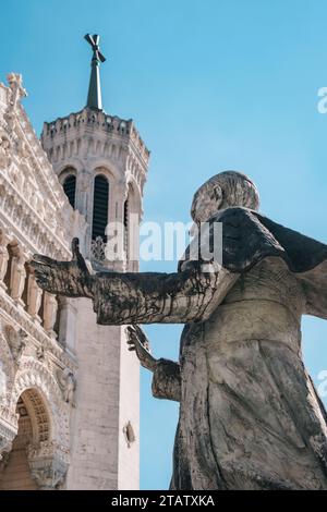 The statue of Pope John Paul II just in front of the Neo-Byzantine white facade of the Basilica of Notre-Dame de Fourvière in Lyon (France) Stock Photo