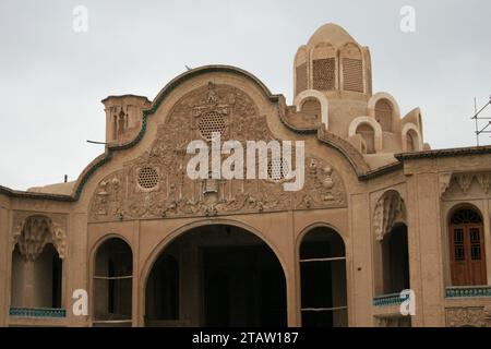 A vintage building exterior on a cloudy day, featuring a parked car outsideg Stock Photo