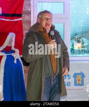 Bridport, Dorset, UK.  1st December 2023.  Actor Martin Clunes switches on the annual display of Christmas Lights which decorate the house of Monica and Rob Teague at White Close at Bradpole in Bridport, Dorset.  The display raises money for Julia’s House Children’s Hospice.  Picture Credit: Graham Hunt/Alamy Live News Stock Photo