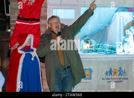 Bridport, Dorset, UK.  1st December 2023.  Actor Martin Clunes switches on the annual display of Christmas Lights which decorate the house of Monica and Rob Teague at White Close at Bradpole in Bridport, Dorset.  The display raises money for Julia’s House Children’s Hospice.  Picture Credit: Graham Hunt/Alamy Live News Stock Photo