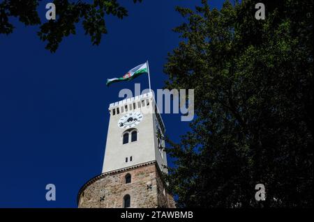 Slovenian national flag flies on Viewing Tower of Ljubljana Castle in Ljubljana, capital of Slovenia.  The Viewing Tower was added between 1845 and 1848 to a medieval fortress that had been comprehensively rebuilt in the 1400s.  The tower stands on an earlier stone, rubble and brick base. Stock Photo
