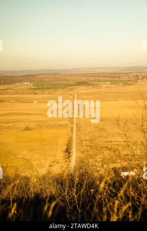 Colorful land and a straight road in the middle, warm light shinning over the beautiful Earth, sunny Stock Photo