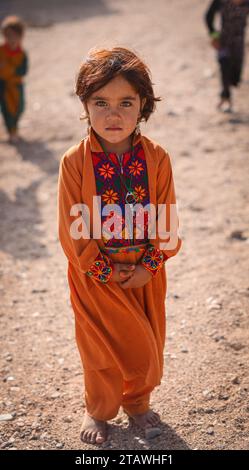 Happy Afghan young girl with a traditional outfit, smiling, looking at the camera. Stock Photo