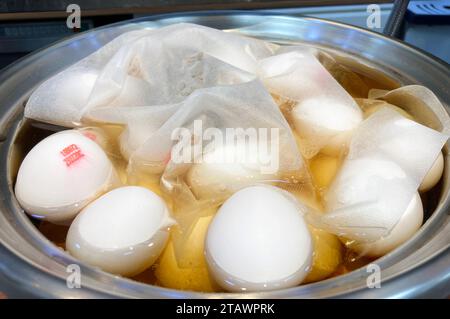 Preparing for culinary delights, a pot holds fresh, uncooked eggs set to transform into flavorful tea eggs. Stock Photo