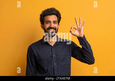 Young smiling indian man making 'OK' gesture at camera Stock Photo