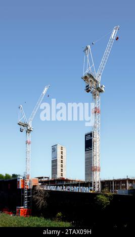 two construction cranes new urban quarter the goods yard developers capital & centric stoke on trent staffordshire with lift shaft concrete core Stock Photo