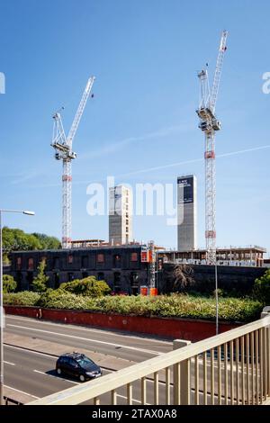 two construction cranes new urban quarter the goods yard developers capital & centric stoke on trent staffordshire with lift shaft concrete core Stock Photo