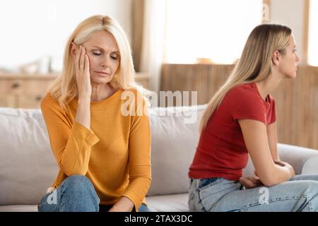 Frustrated women grown up daughter and mature mother sit aside Stock Photo