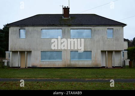 Disused condemned houses boarded up with steel shutters Stock Photo