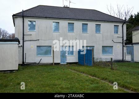 Disused condemned houses boarded up with steel shutters Stock Photo