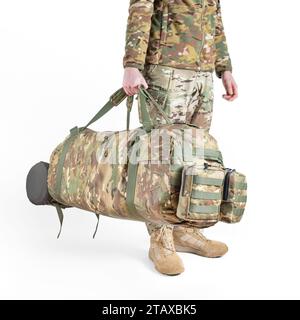 Soldier in a military uniform holds camouflage bag in his hands on white background. Armed forces concept. Stock Photo