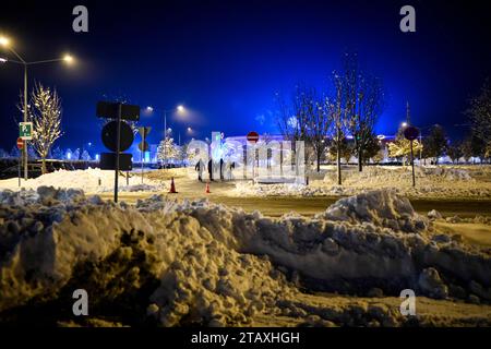 Augsburg, Germany. 03rd Dec, 2023. Soccer: Bundesliga, FC Augsburg - Eintracht Frankfurt, Matchday 13, WWK Arena. Spectators walk between mountains of snow to the WWK Arena. Credit: Tom Weller/dpa - IMPORTANT NOTE: In accordance with the regulations of the DFL German Football League and the DFB German Football Association, it is prohibited to utilize or have utilized photographs taken in the stadium and/or of the match in the form of sequential images and/or video-like photo series./dpa/Alamy Live News Stock Photo