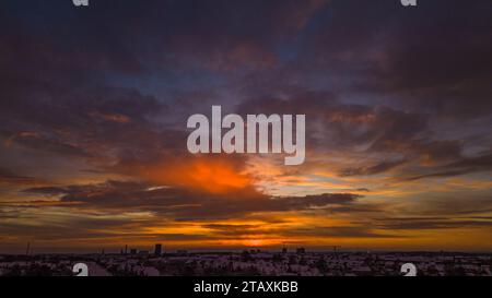 sunset with clouds over snow covered suburban area Stock Photo