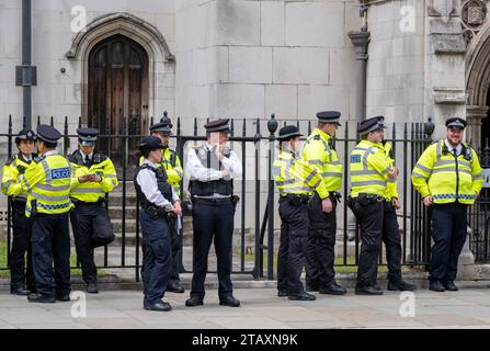 Metropolitan Police officers on stand-by, wearing high visibility jackets, to escort and monitor a street protest demonstration through central London Stock Photo