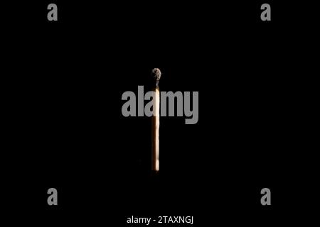 Lit and falling match on a black background. Stock Photo