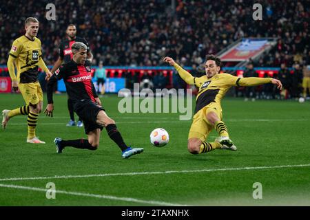 Leverkusen, Germany. 03rd Dec, 2023. Soccer: Bundesliga, Bayer Leverkusen - Borussia Dortmund, Matchday 13, BayArena. Dortmund's Mats Hummels (r) blocks a shot from Leverkusen's Exequiel Palacios. Credit: Marius Becker/dpa - IMPORTANT NOTE: In accordance with the regulations of the DFL German Football League and the DFB German Football Association, it is prohibited to utilize or have utilized photographs taken in the stadium and/or of the match in the form of sequential images and/or video-like photo series./dpa/Alamy Live News Stock Photo
