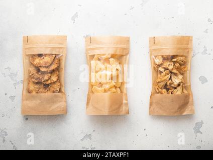 Packages with dried sweet pineapple slices and chips on light background. Stock Photo