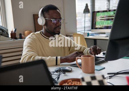 Young man programming on laptop working on new application Stock Photo