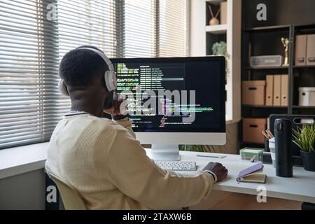Pensive software developer searching way to fix bugs in programming code Stock Photo