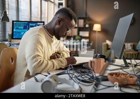 Pensive programmer writing down his ideas when working on project Stock Photo