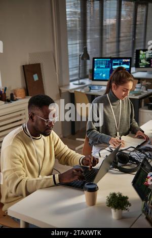 Young developers working in small office of IT company Stock Photo