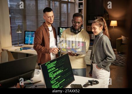 Group of software developers launching program on laptop to check how it works Stock Photo