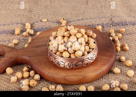Hazelnut varieties in copper bowl on linen background. Roasted shelled hazelnuts, shelled hazelnuts and shellless roasted hazelnuts. Healthy food conc Stock Photo